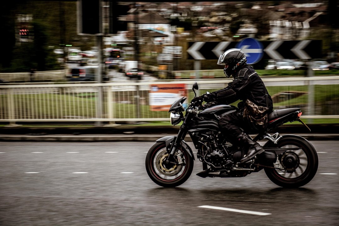 Motorcycle rider wearing all black apparel