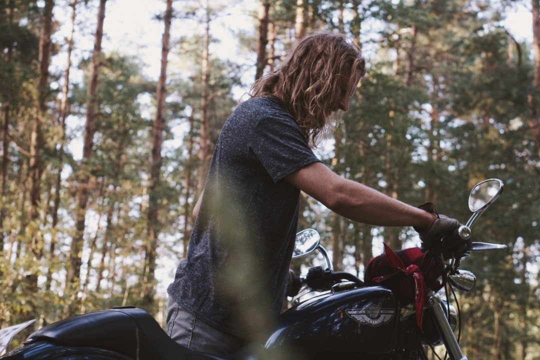 Homme garant un custom sur un bloque roue moto