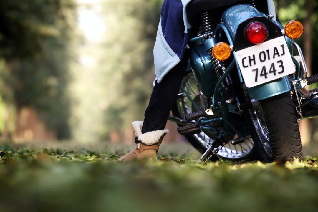 Femme sur une moto 125 garée en bord de route