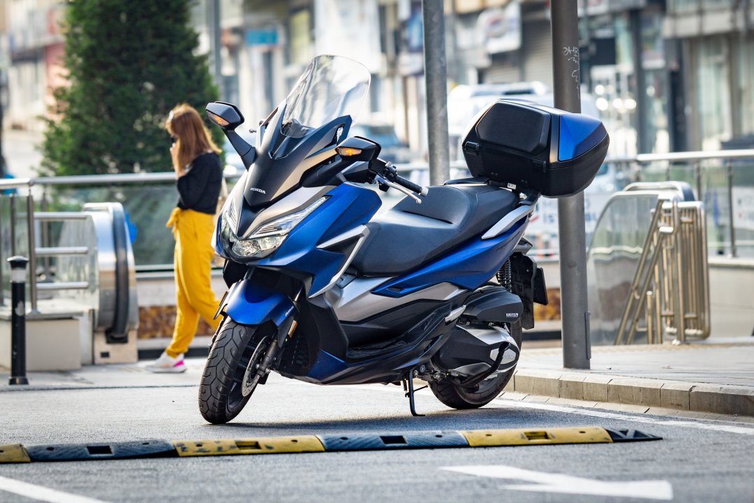 Scooter Honda Forza 125 de couleur bleue garé dans la rue