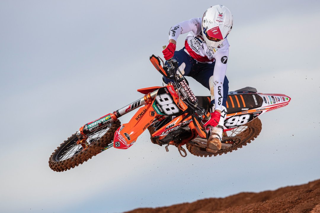 Homme pilotant réalisant une figure sur une motocross orange