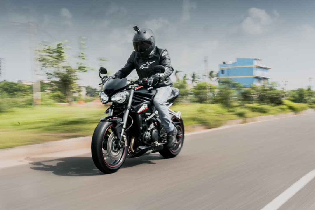 Personne conduisant une moto roadster de couleur noire