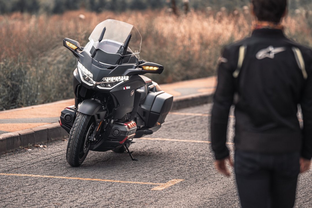 Moto routière Honda GL 1800 Gold Wing noire garée en bord de route