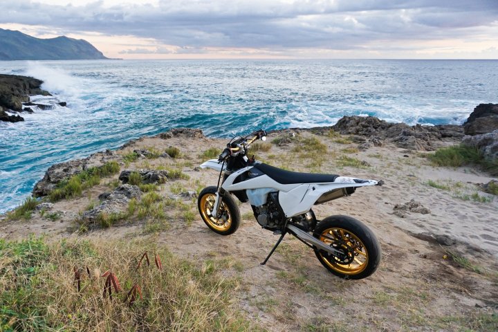 Moto supermotard de couleur blanche garée en bord de mer