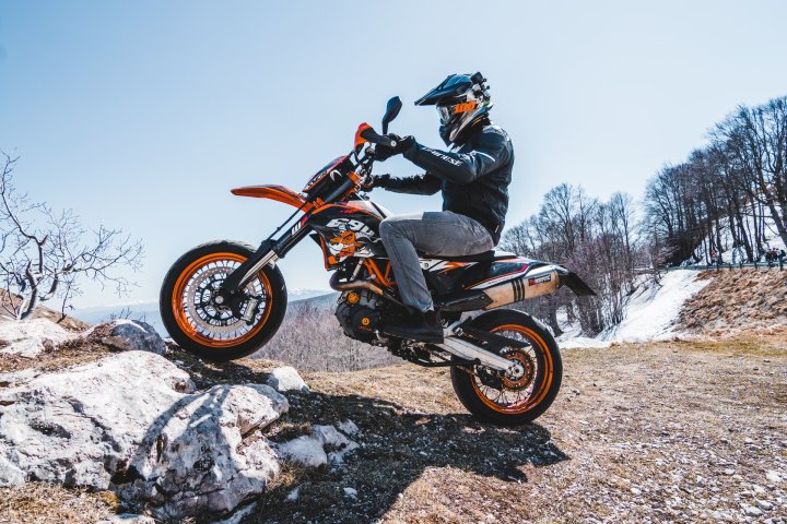 Homme pilotant une moto supermotard dans la colline