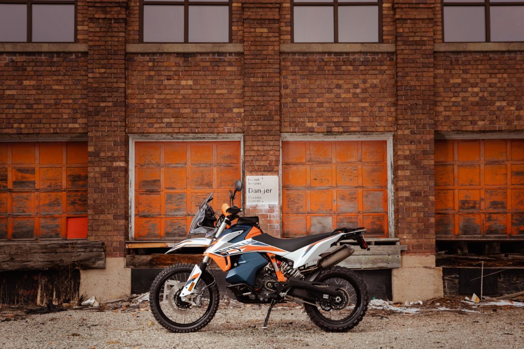 Trail KTM 890 Adventure garé devant un bâtiment de briques