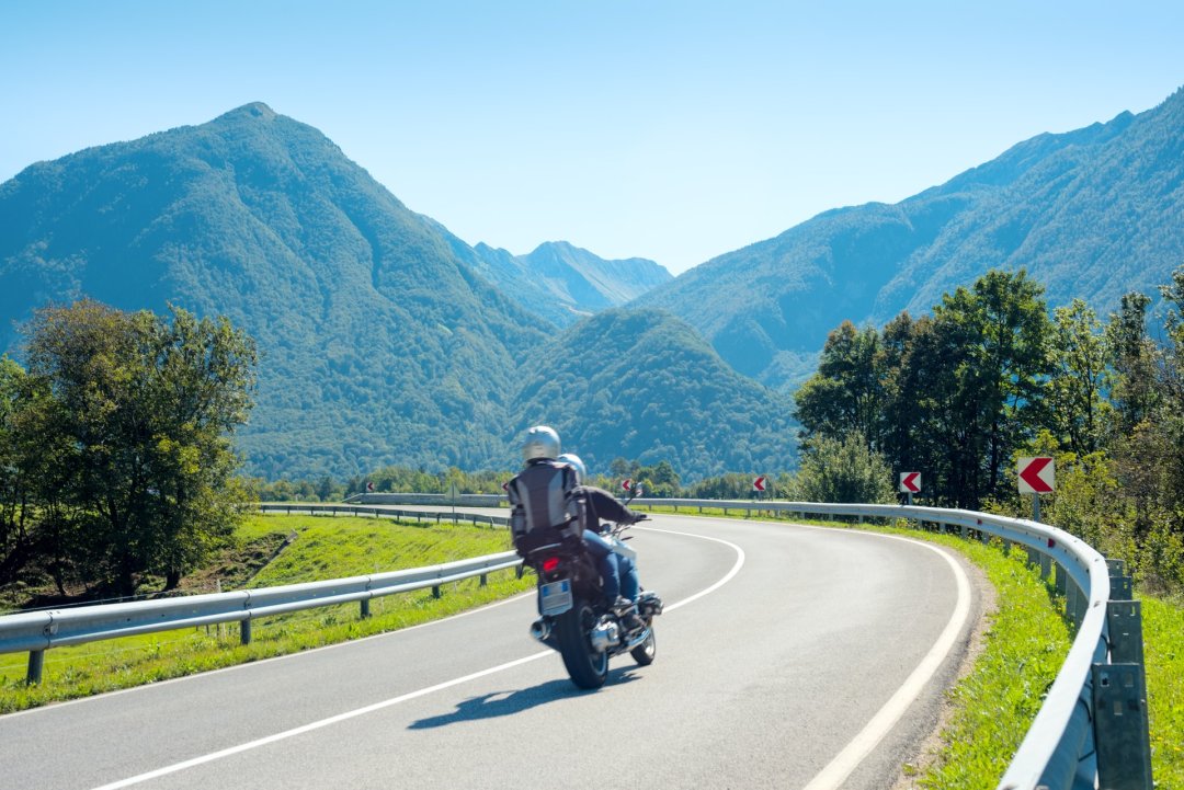 Couple en roadtrip moto dans un paysage de montagne