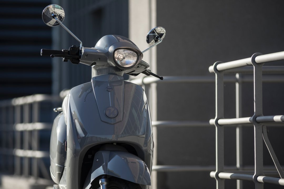 Scooter électrique de couleur grise garé dans la rue